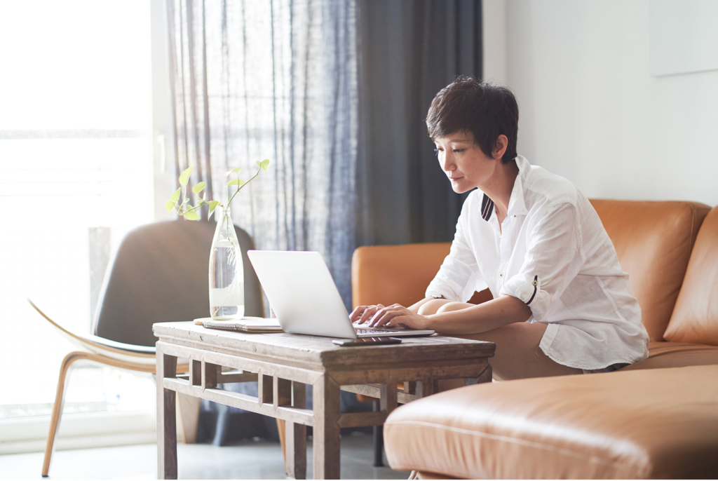 woman with short hair works on laptop at home